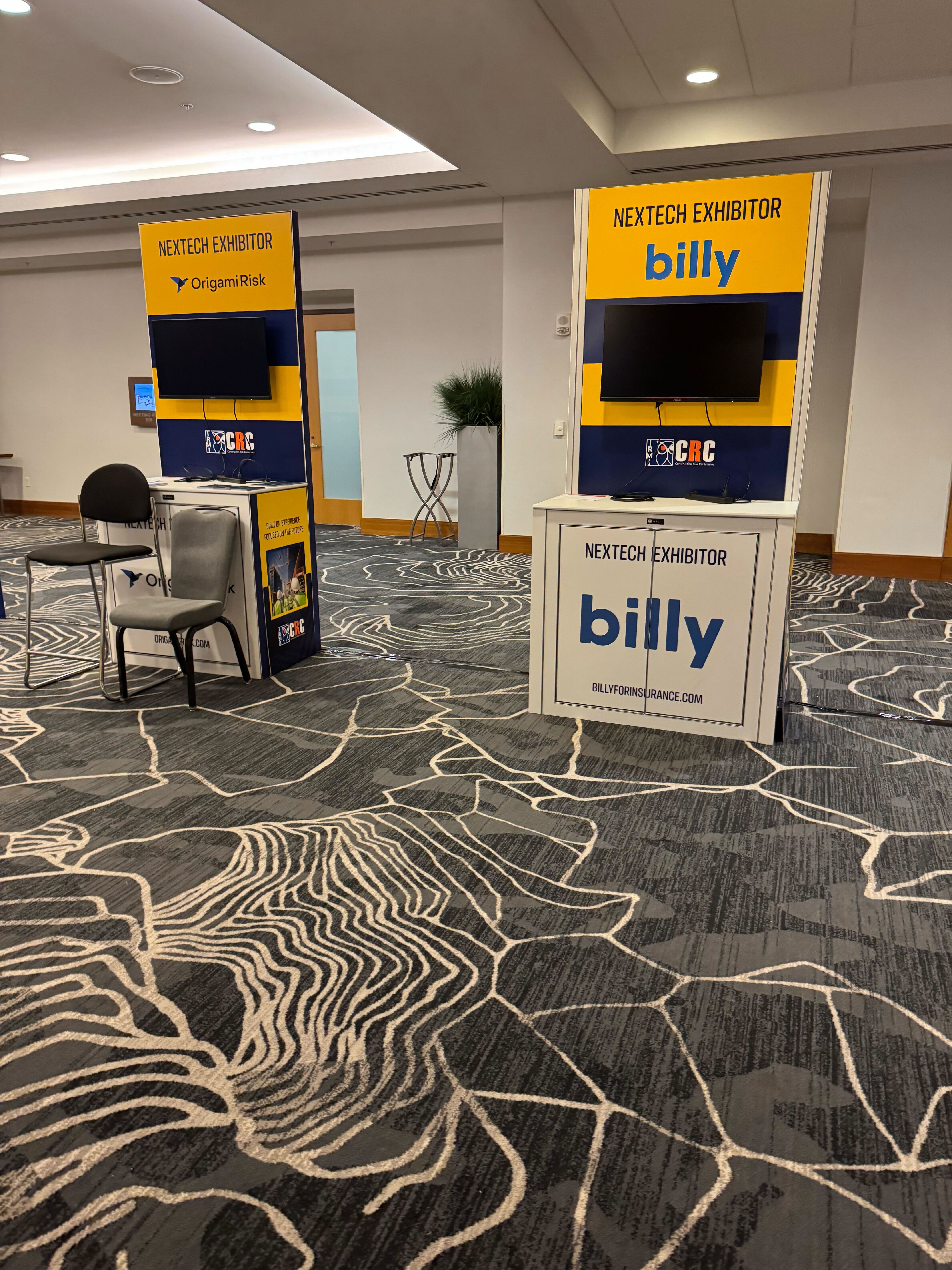 Billy's NexTech Exhibitor kiosk at IRMI CRC with a mounted screen and the IRMI CRC logo