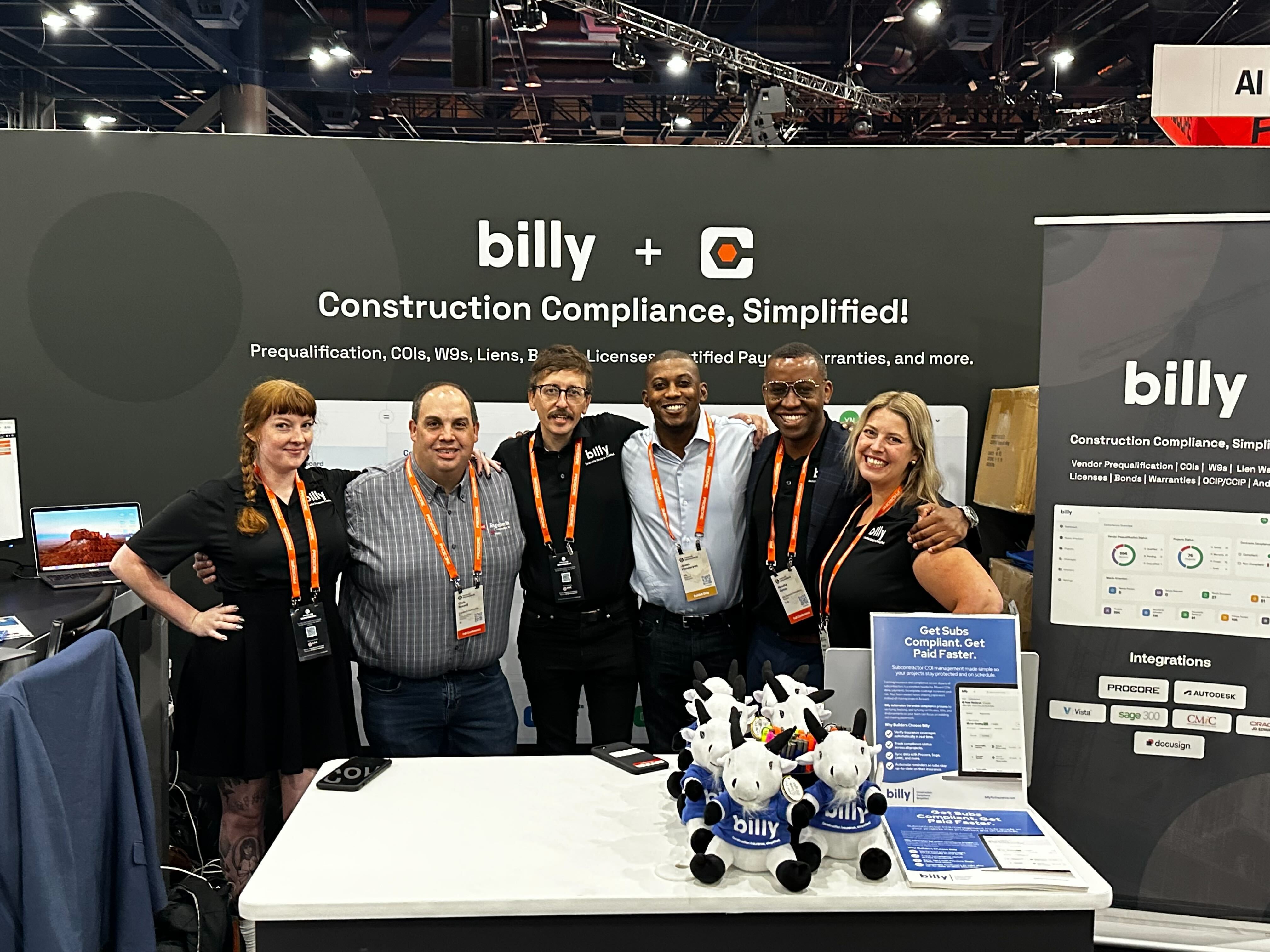 The Billy team at a conference booth with a backdrop reading Construction Compliance, Simplified