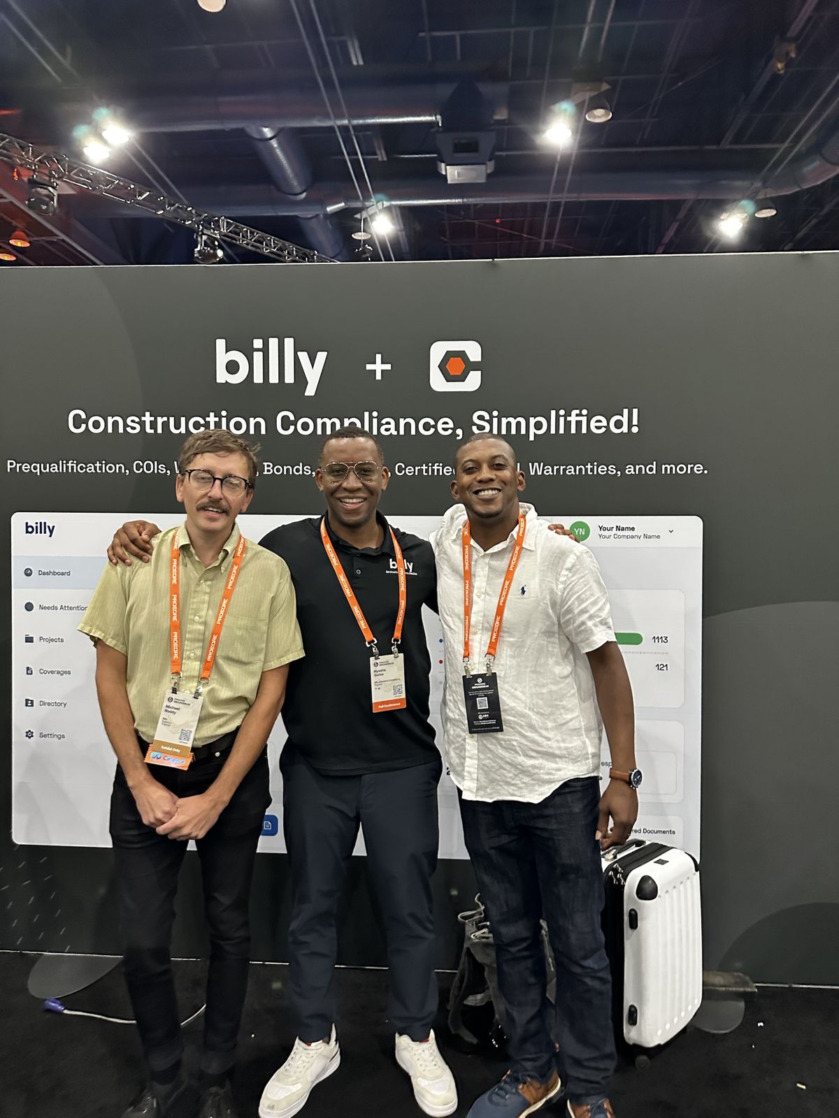 The Billy team in front of the Billy and Procore construction compliance dashboard at Procore Groundbreak